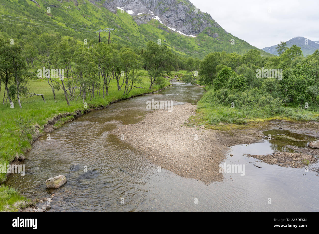 Circolo polare artico paesaggio con shoal e chiare acque del fiume Hegdal tra brich legno nel verde paesaggio collinare, girato sotto la luminosa luce nuvoloso vicino Foto Stock