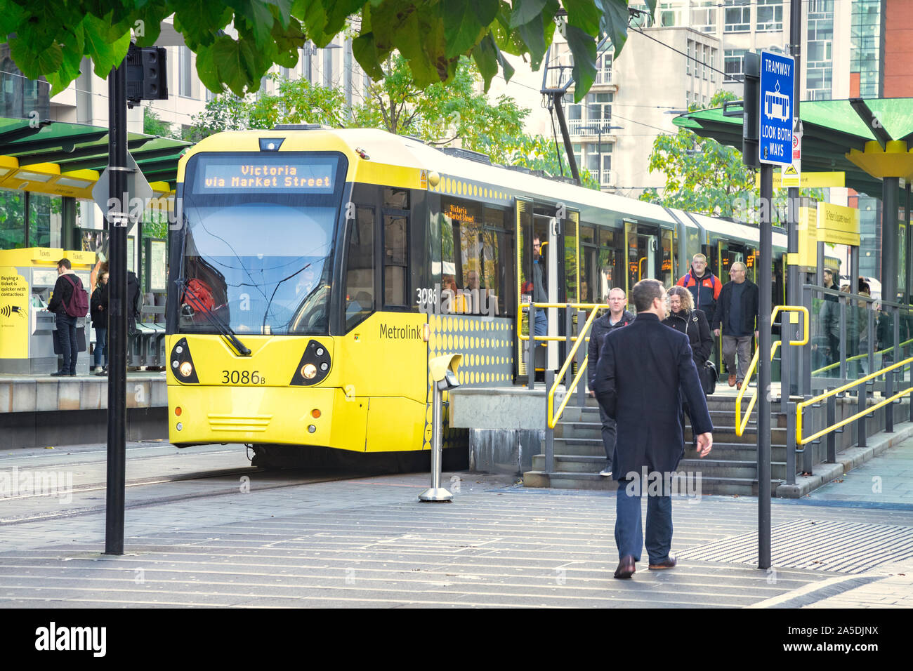 2 Novembre 2018: Manchester, Regno Unito - Metrolink tram alla fermata del tram in Piazza San Pietro in CBD, persone salire e scendere. Foto Stock