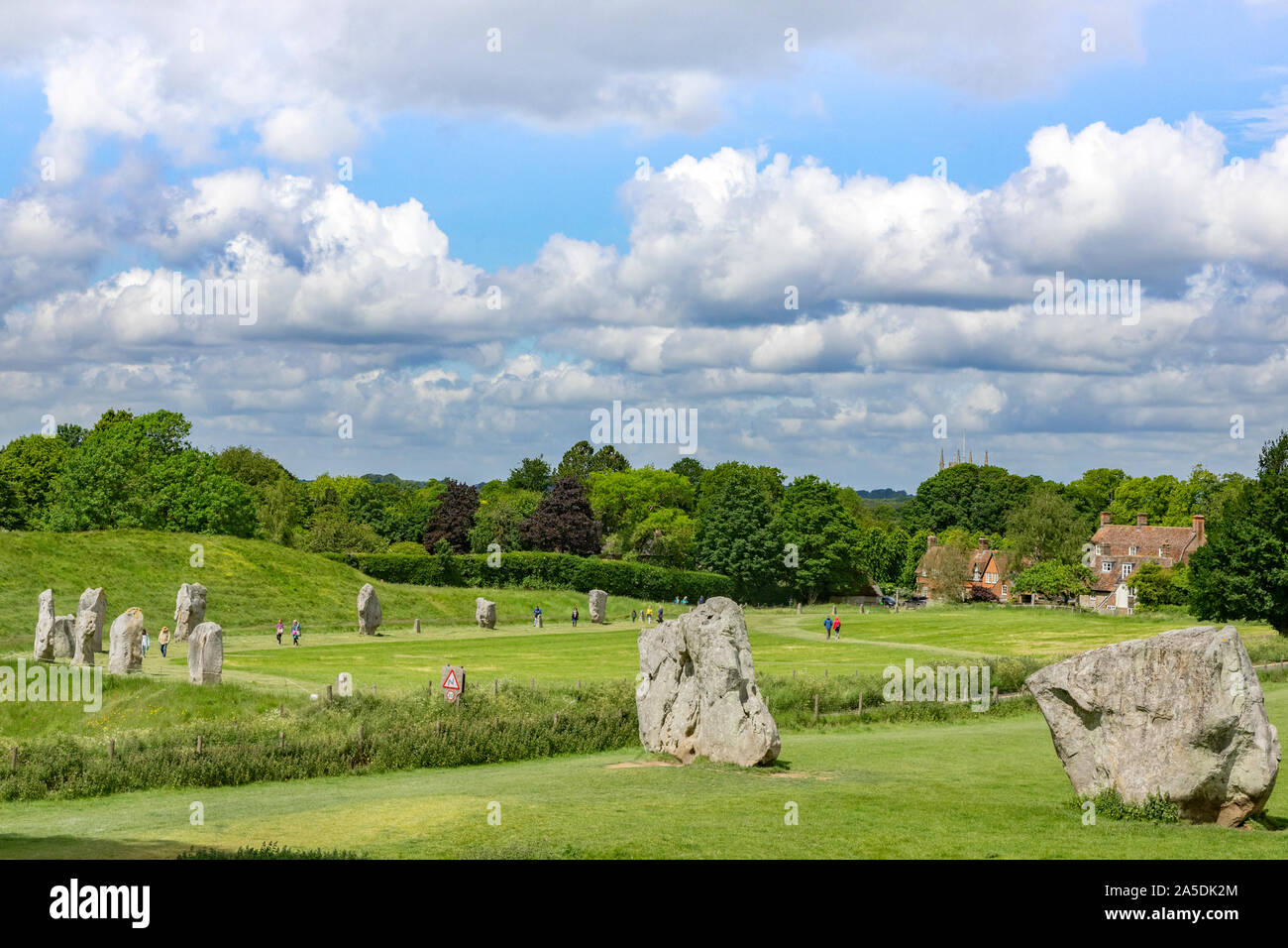 8 Giugno 2019: Avebury, Wiltshire, Regno Unito - i turisti passeggiano attorno all'Avebury Stone Circle, il più grande henge in nworld, su un luminoso giorno d'estate. Foto Stock