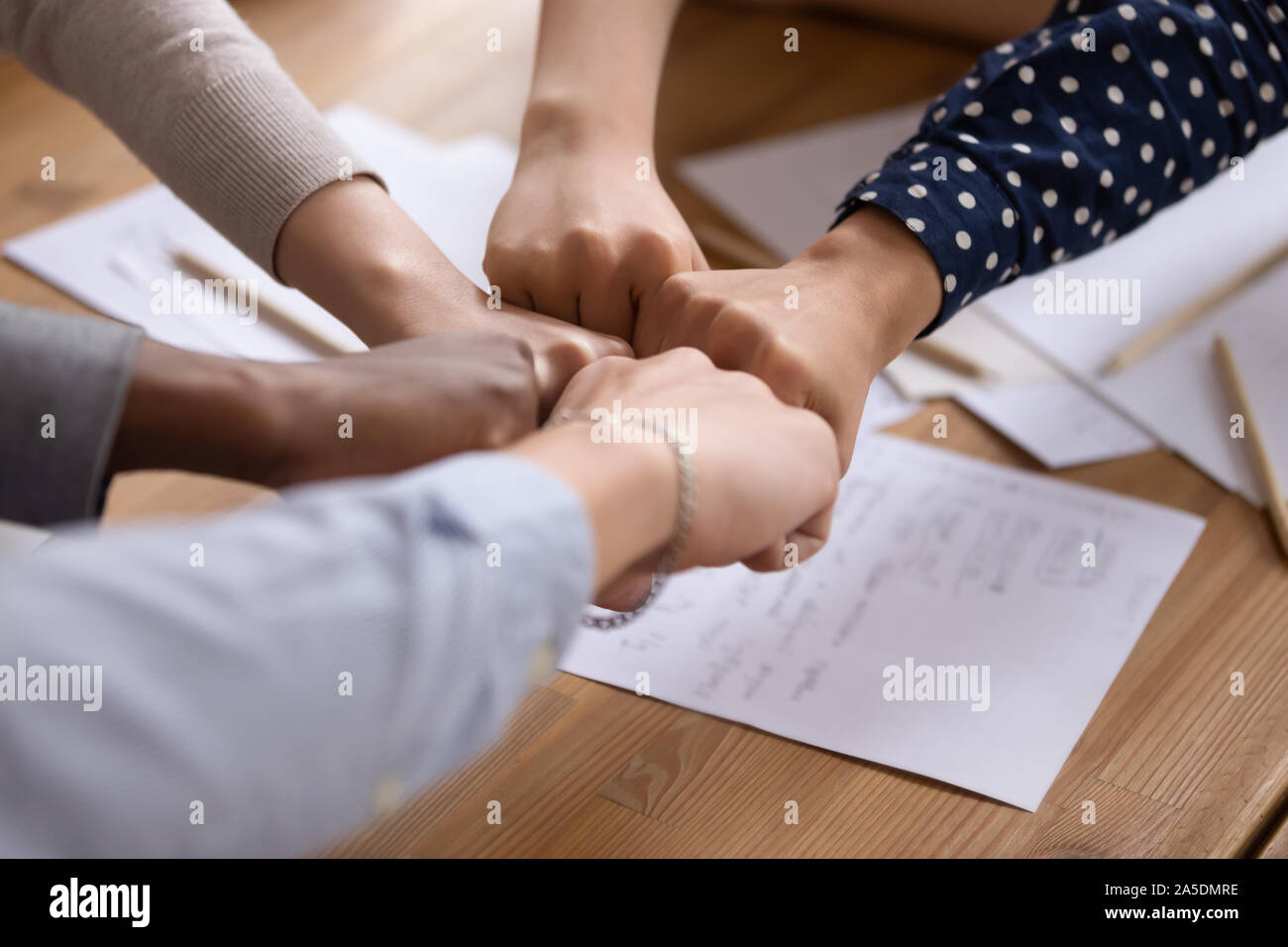 Diverse persone mettere i pugni in cerchio come simbolo di unità Foto Stock