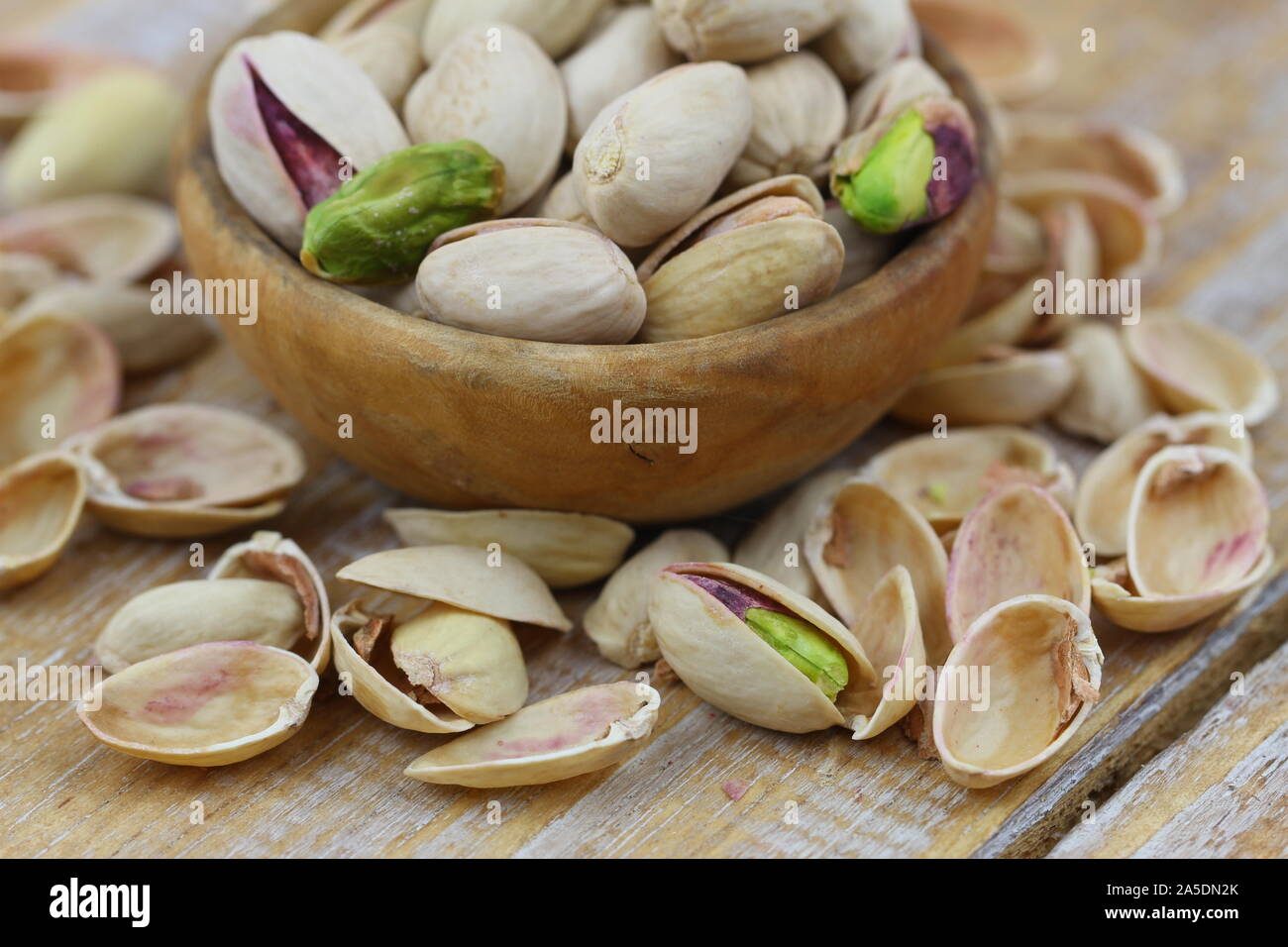 Pistacchio tra aprire il pistacchio nutshells su una superficie di legno Foto Stock