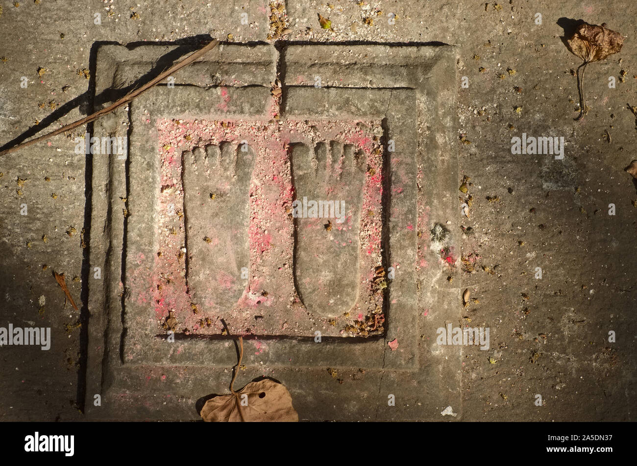 La parte superiore di una tomba in Shree Santosh Giri Dashnami Akhada cimitero, con una simbolica impressione di Vishnu le impronte; Walkeshwar, Mumbai, India Foto Stock