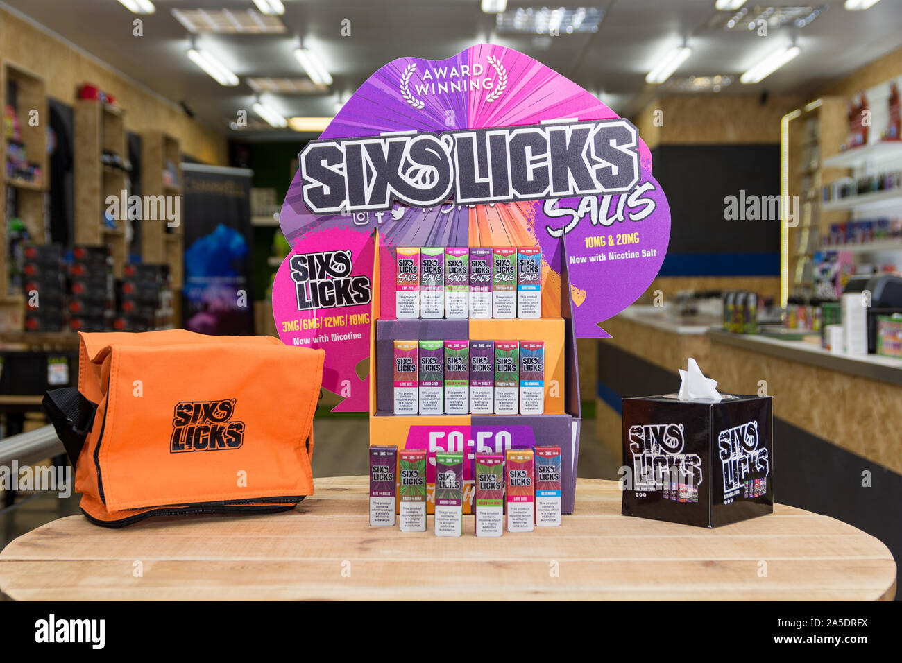Sei lambisce e-stand di liquido e la merce sul display interno un scozzese vape shop Foto Stock