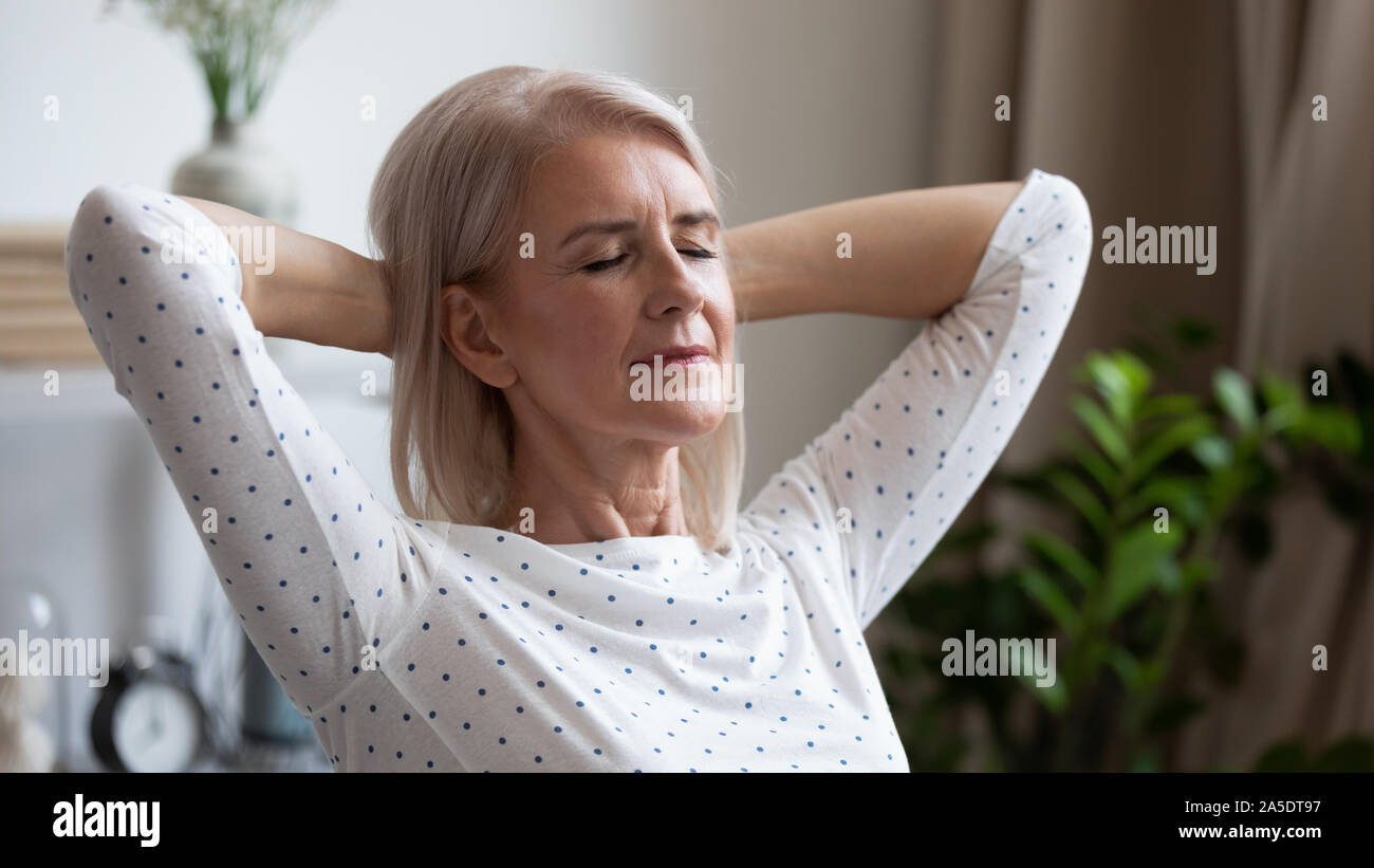 Calma serena donna matura in appoggio con gli occhi chiusi a casa Foto Stock