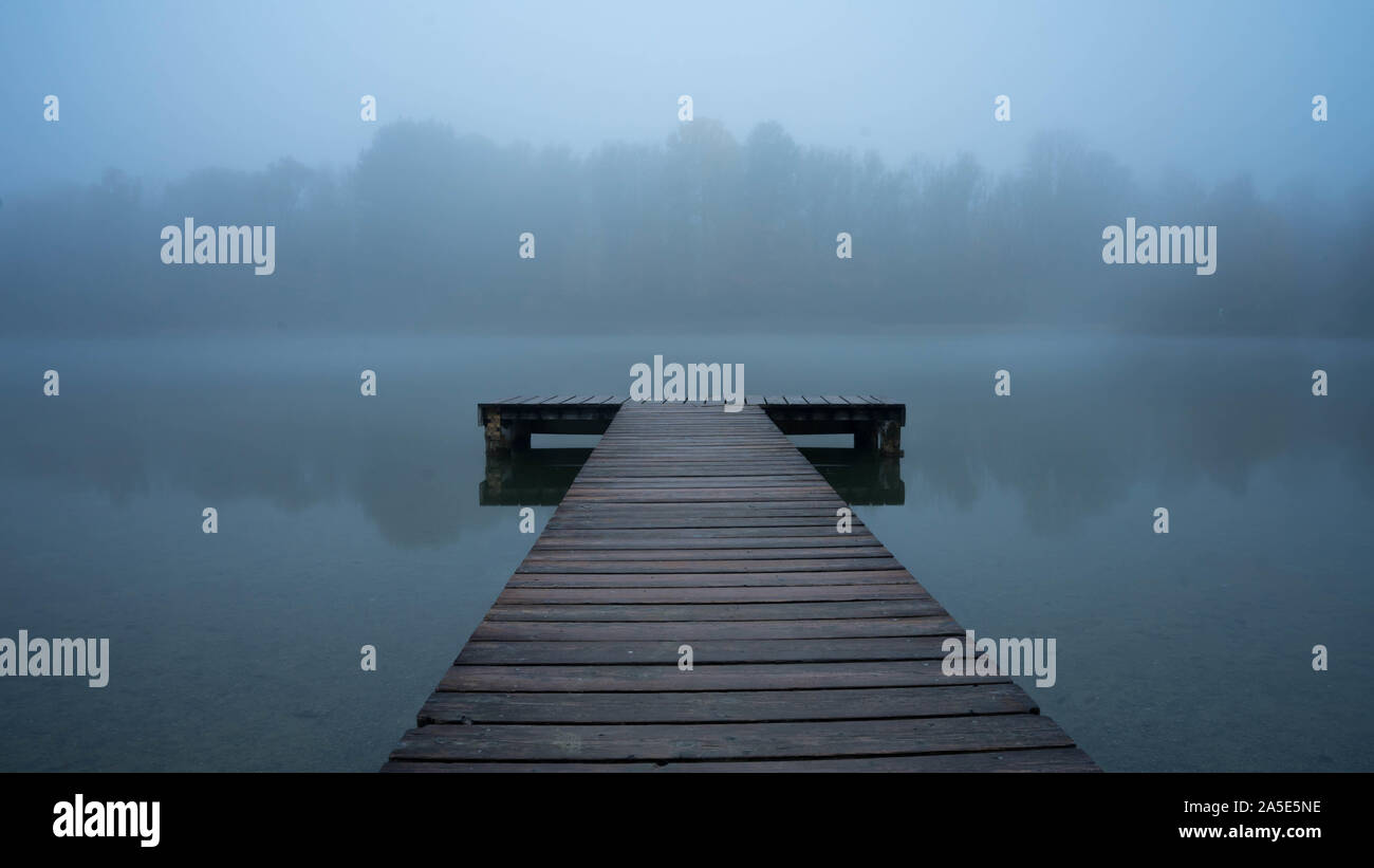 Pontile vuota su un inizio mattinata nebbiosa presso un lago tedesco Foto Stock