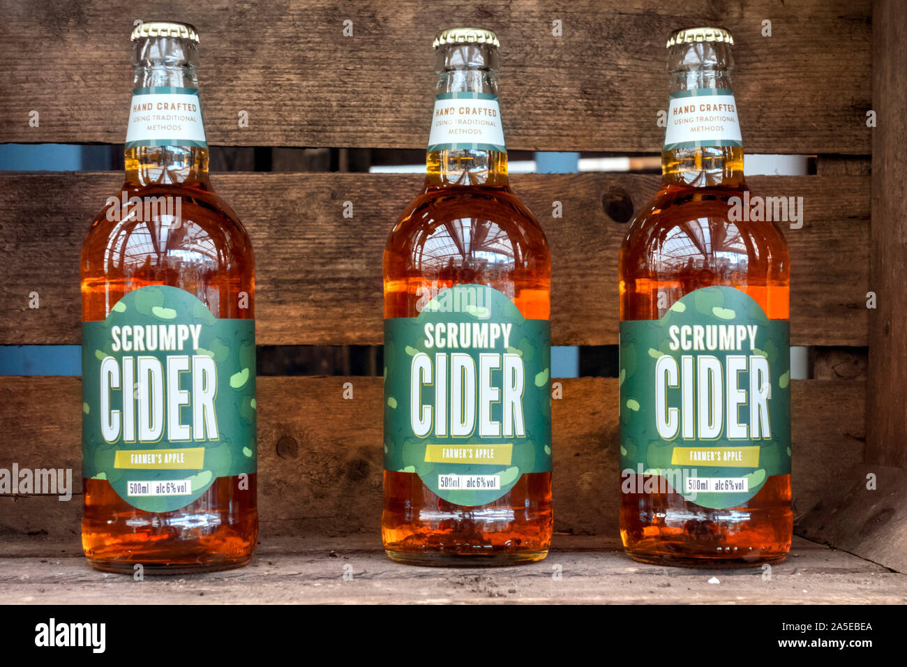 Tre bottiglie di agricoltore e la Apple Scrumpy sidro in casse di legno Hertfordshire, Regno Unito Foto Stock