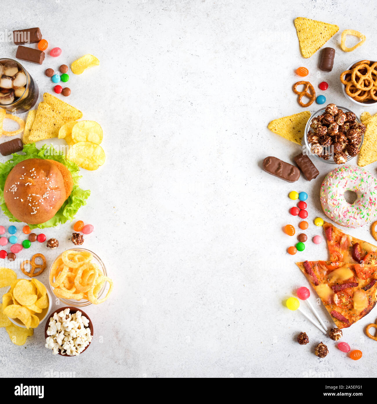 Set di cibo malsano su bianco, vista dall'alto, copia dello spazio. Malsano, mangiare cibo spazzatura o snack TV concetto. Foto Stock