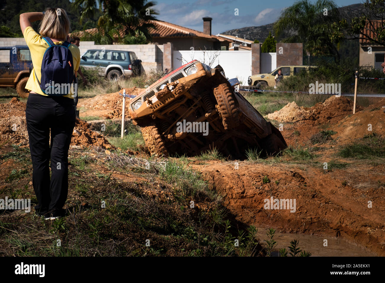 Donna Fotografa 4x4 veicolo offroad cercando di ottenere al di fuori della trincea profonda a caso sul corso preparato a Barx in Spagna Foto Stock