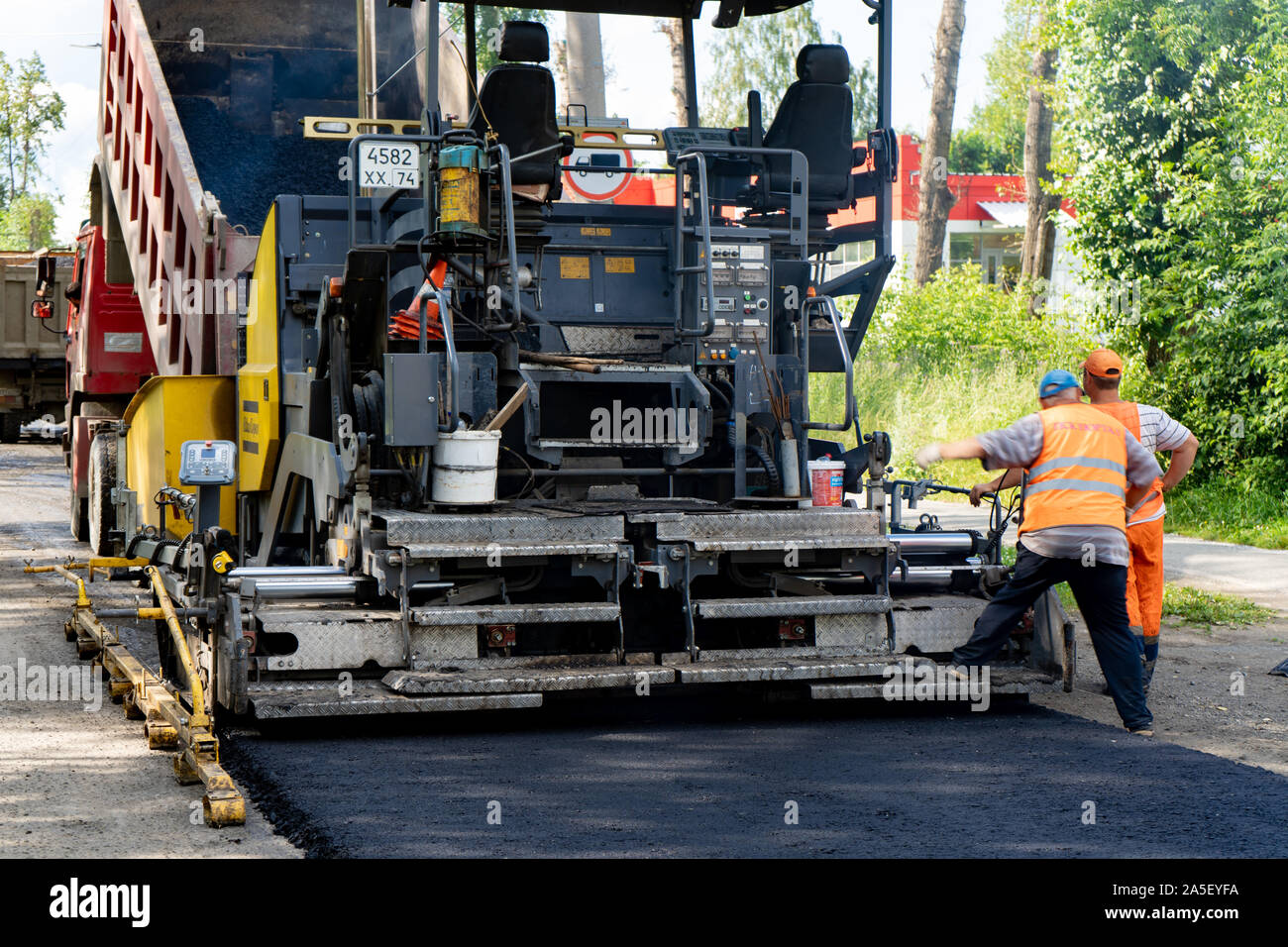 La regione di Celjabinsk, Russia - Agosto 2019. Nuovo lastricatore in azione. Riparazione su strada. Asfalto da pavimentazione. La posa di un nuovo strato di asfalto Foto Stock