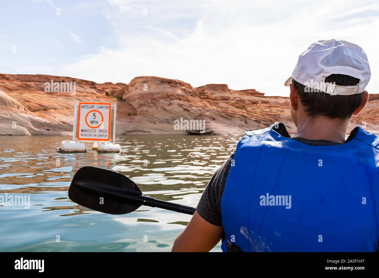 Uomo in kayak sul lago Powell con la vista del canyon acqua e segno per Antelope Canyon il limite massimo di velocità di riattivazione zona wakeless per barche e canoisti Foto Stock