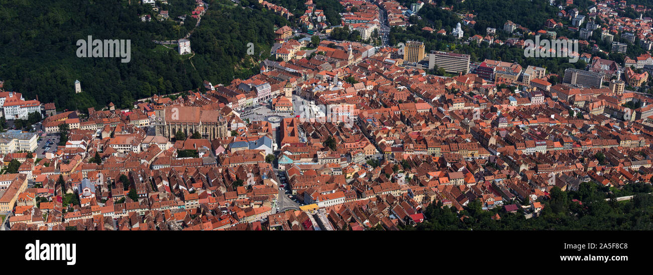 Vista aerea e il panorama della Città Vecchia, Brasov con una vecchia torre dell orologio al centro della piazza e o sacco di tetti rossi. Transilvania, Romania. Foto Stock