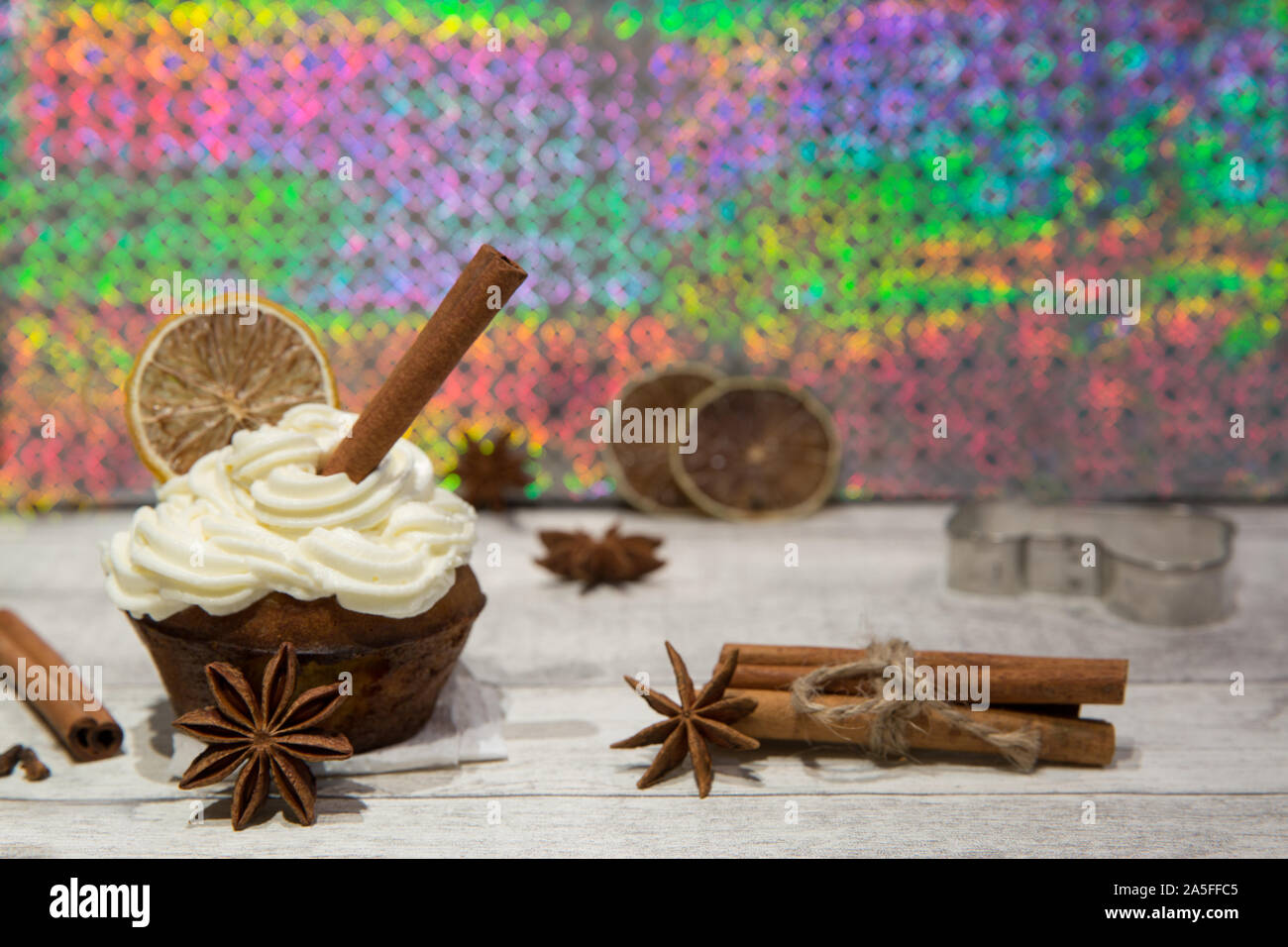 Holiday cupcake con glassa di mascarpone, essiccate di agrumi, arancio, limone e decorazione di calce, cookie cutter, cimmanon rotoli e anice stelle. Luminose colo Foto Stock