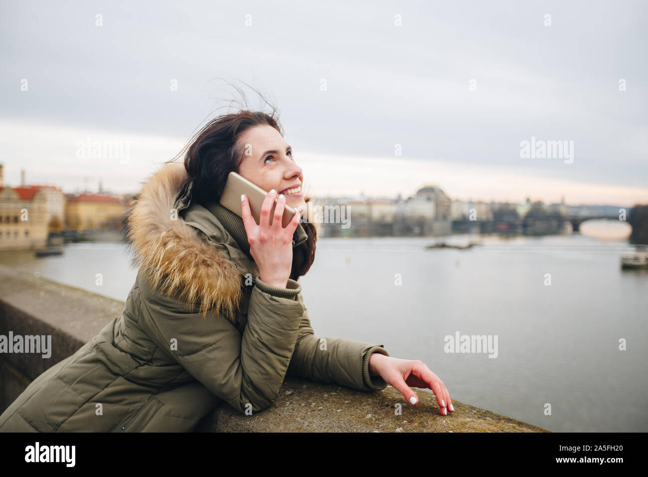 Sorridente donna turistici a Praga parlando sullo smartphone. Giovane donna tourist sorge sul Ponte Carlo a Praga nella Repubblica ceca utilizza phone Foto Stock