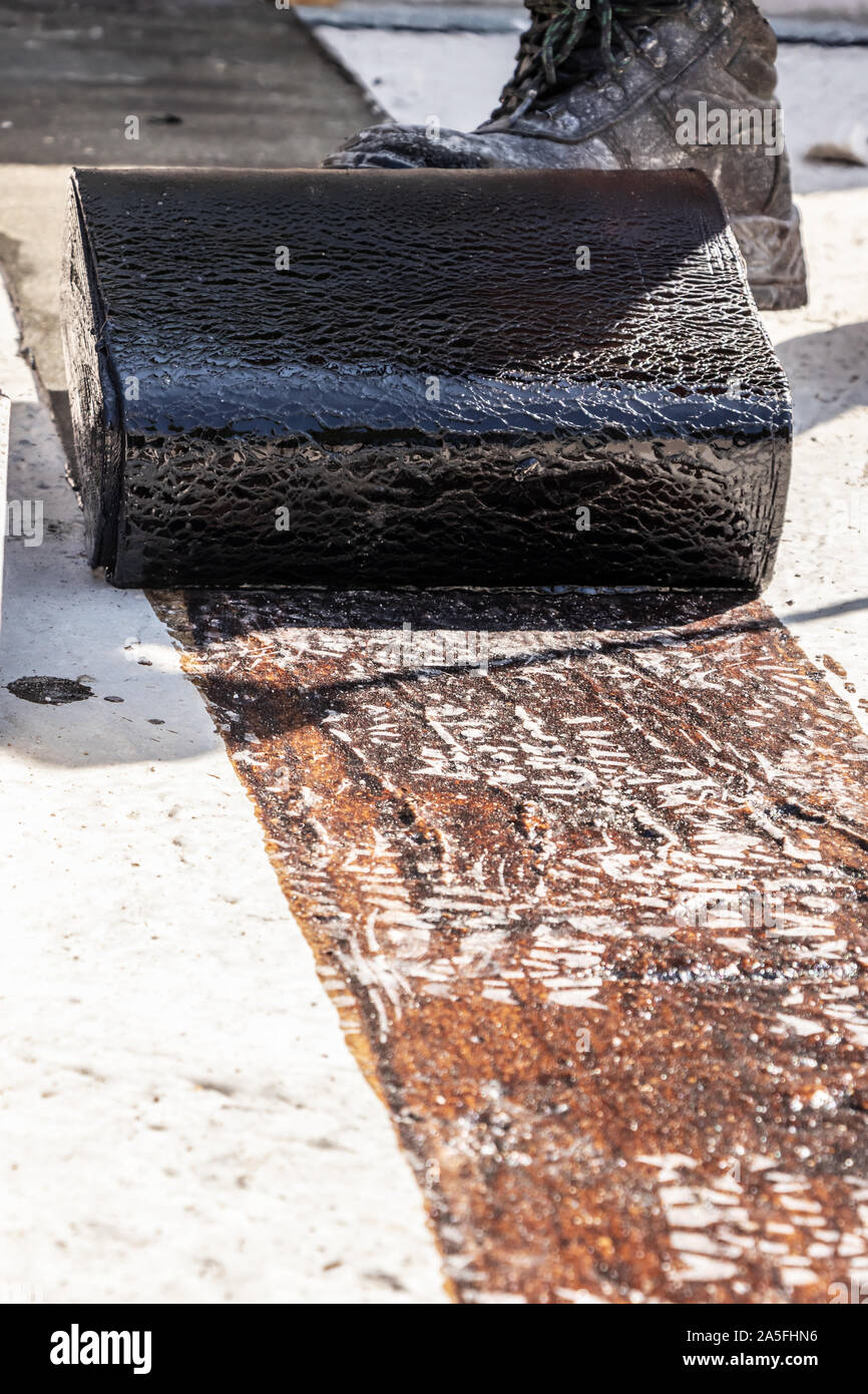 La posa di tar carta su un sito in costruzione Foto Stock