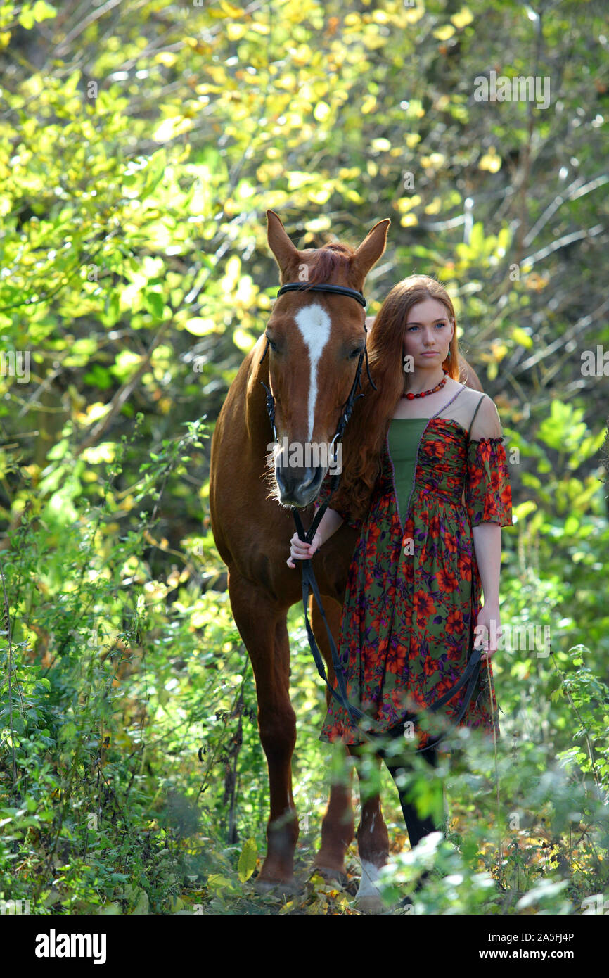 Bel paese ragazza bareback cavalcare il suo cavallo in autunno country road al tramonto Foto Stock