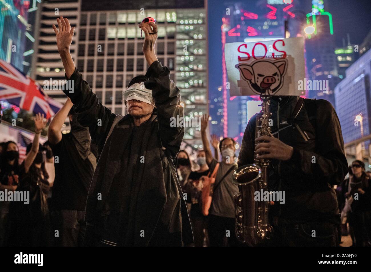 Protester svolge un sassofono durante la dimostrazione.la gente di Hong Kong chiamata per International SOS e umanità aiuto al posto di Edimburgo, Centrale in una dimostrazione contro l'Anti-mask legge. Hong Kong è chief executive Carrie Lam invocato l uso dei regolamenti di emergenza ordinanza (ERO) consentendo al governo di vietare l'uso di maschere in pubbliche riunioni. Foto Stock