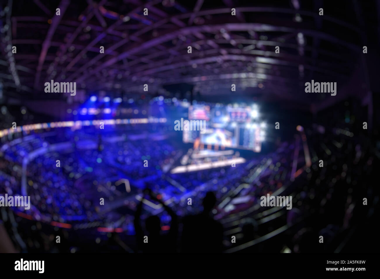 Sfocare lo sfondo di un evento di esports - Grande illuminato stadio principale di un computer games torneo situato su di un grande stadio. Il suo giro di tribune sono pieni di vide Foto Stock