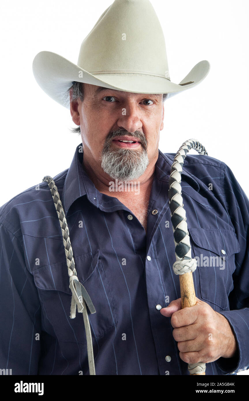 Il vecchio cowboy tenendo un bullwhip sulla sua spalla Foto Stock