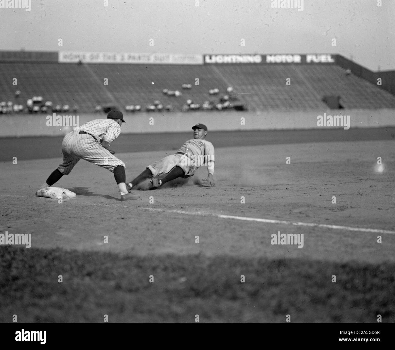 Yankees Babe Ruth fuori in quinta inning cercando di passare dal primo al terzo su Lou Gehrig è unico. Senatori terzo baseman è Ossie Bluege. Yankees ha vinto 3-2. Foto Stock