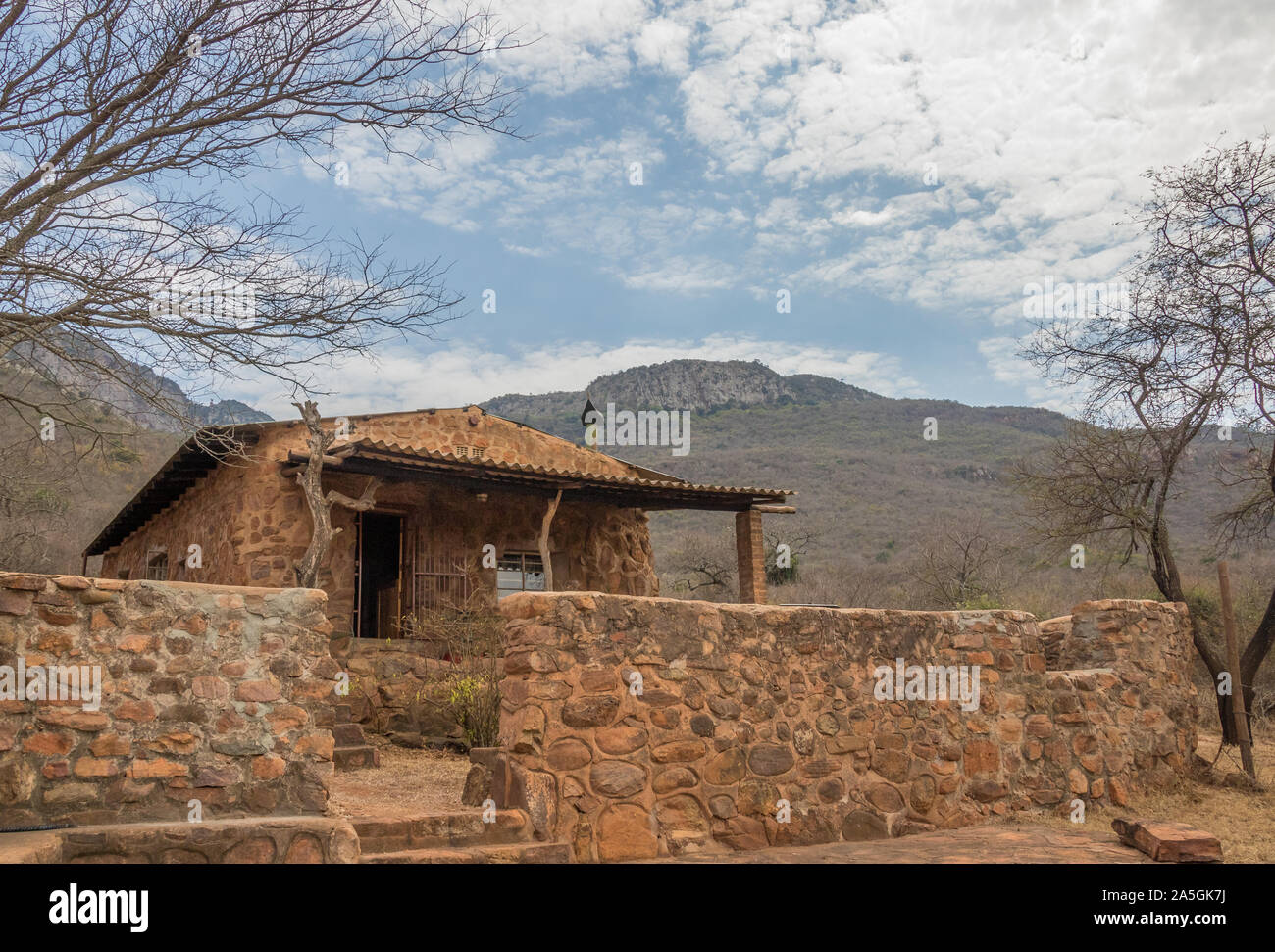 Un vecchio cottage in pietra alla base di una montagna immagine con spazio copia in formato orizzontale Foto Stock