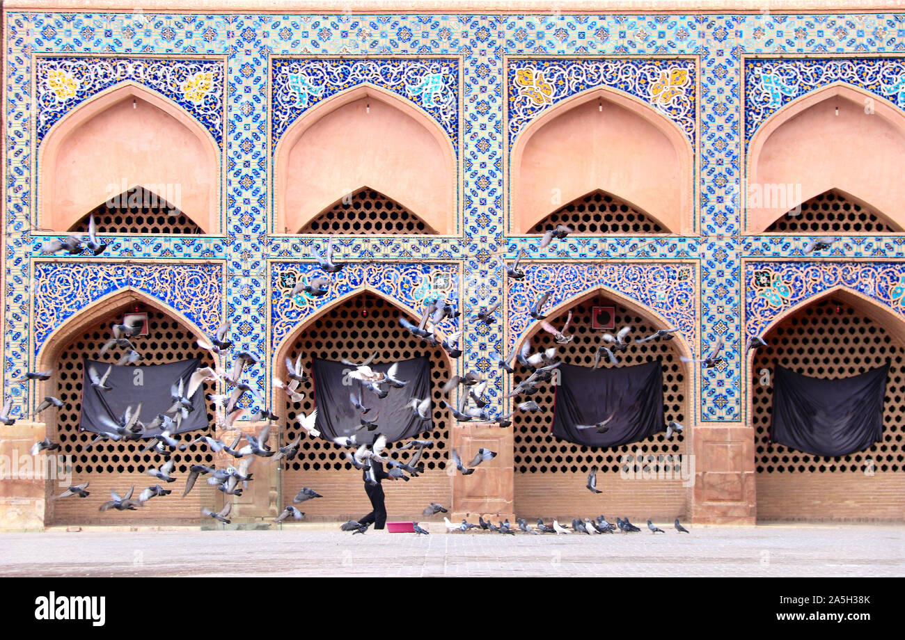 Alimentazione dei piccioni nel cortile di Masjid-e Moschea Jameh (moschea Jame, Venerdì Moschea), di Isfahan, Iran. Patrimonio mondiale dell UNESCO Foto Stock