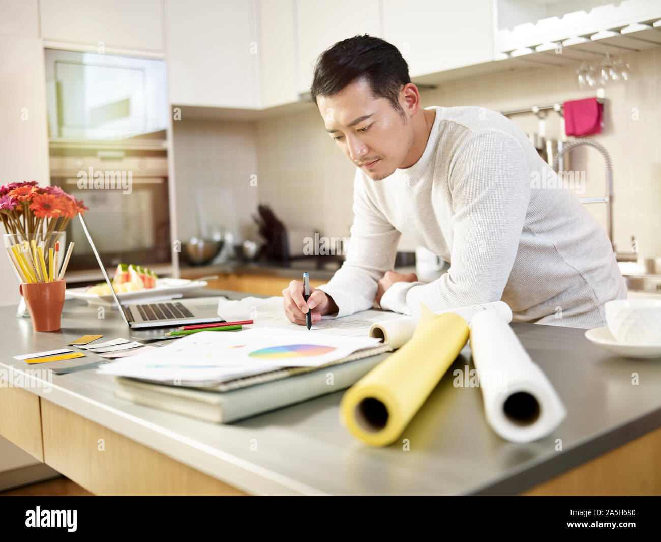 Giovani asiatici designer che lavora da casa disegno su carta di redazione Foto Stock