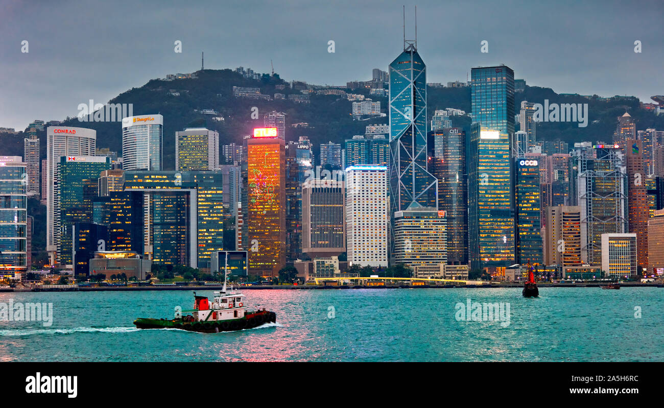 Lungomare centrale edifici illuminati al crepuscolo. Hong Kong, Cina. Foto Stock