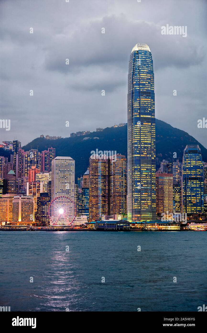 Centro finanziario internazionale (IFC) e altri edifici moderni a livello centrale lungomare illuminato al crepuscolo. Hong Kong, Cina. Foto Stock