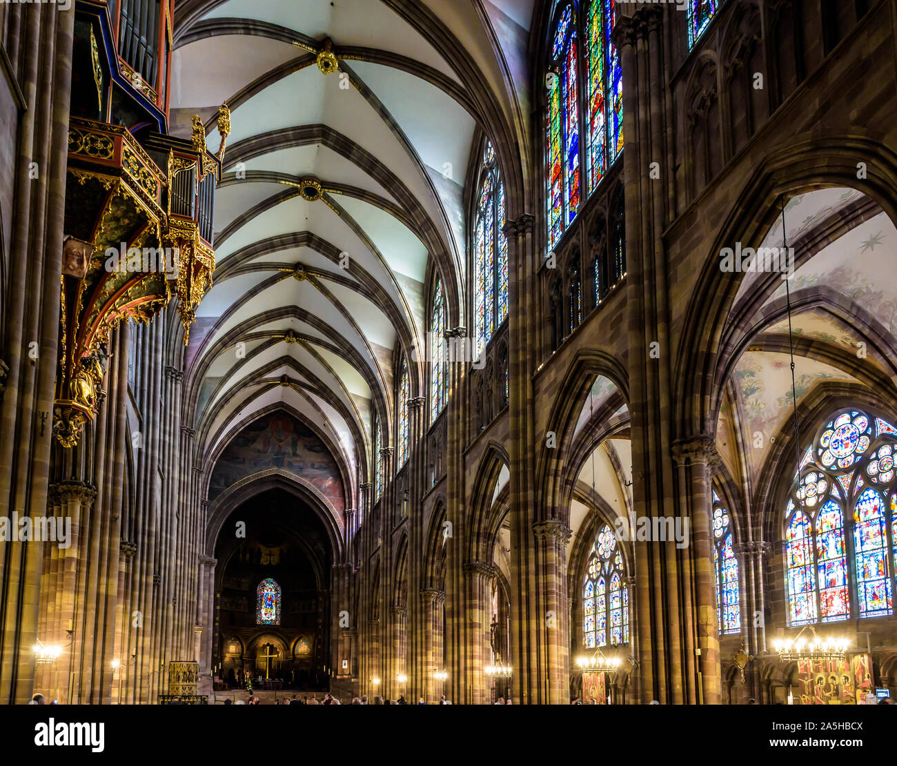Lungo la navata e il coro della cattedrale di Notre Dame a Strasburgo, Francia, illuminato dalla luce solare con la sospensione di organi della tubazione sulla sinistra. Foto Stock