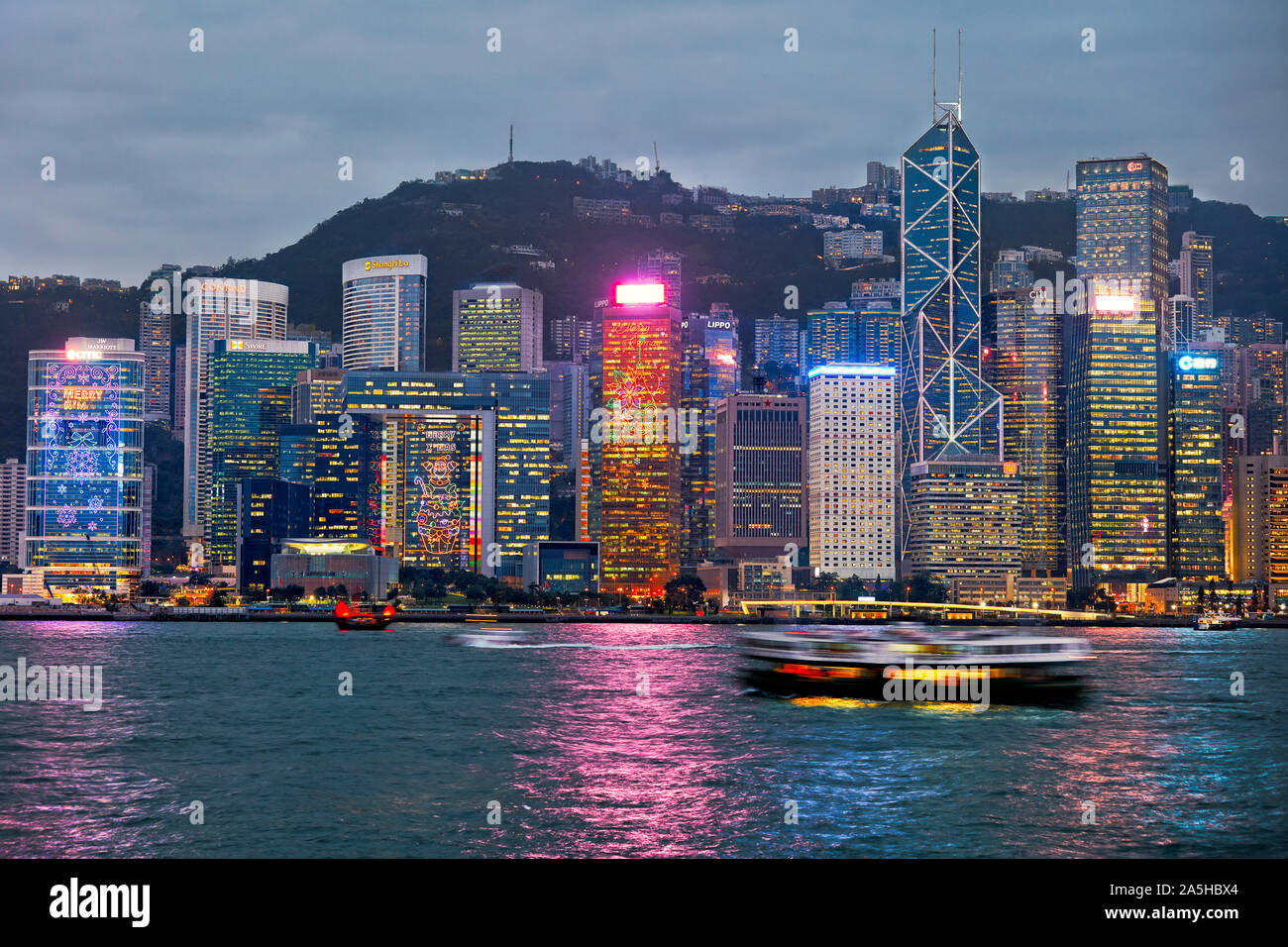 Lungomare centrale edifici illuminati al crepuscolo. Hong Kong, Cina. Foto Stock