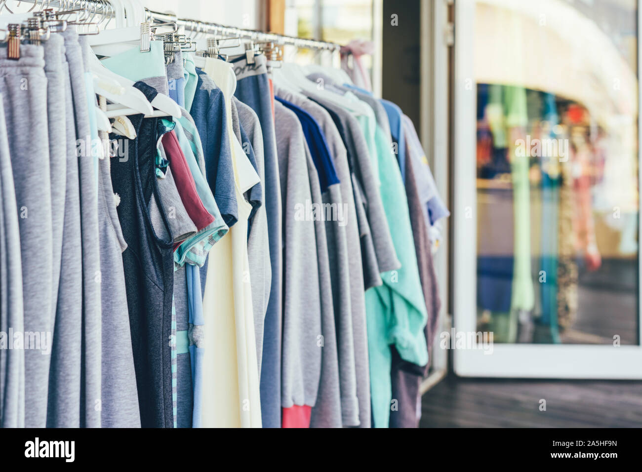 Nello showroom, cose semplici appendere in una fila su appendiabiti. Foto Stock