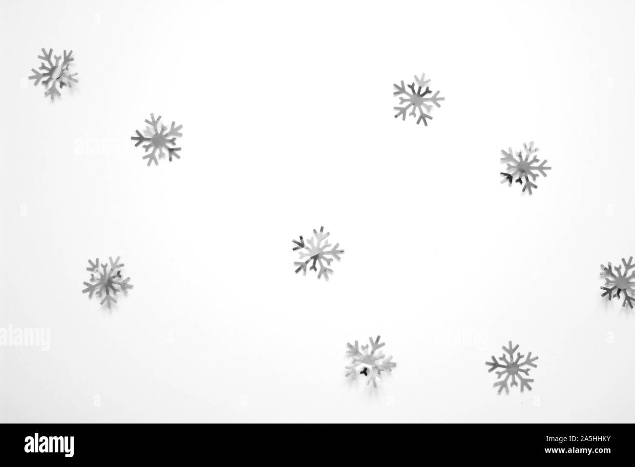 Fiocchi di neve glitter decorazioni su uno sfondo bianco. Abstract Festività Natalizie sullo sfondo. Decor e design pattern. Foto Stock