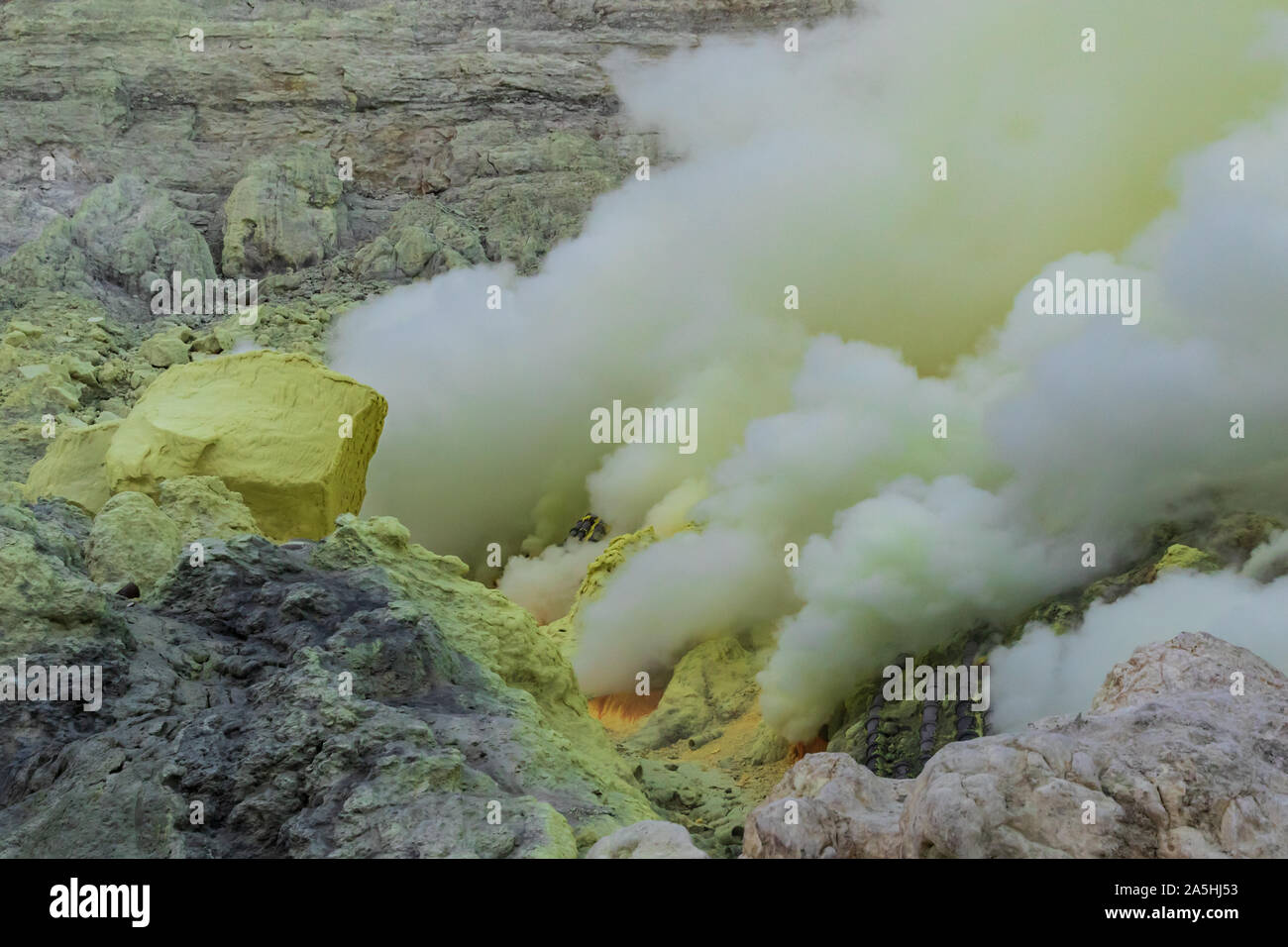 Fumo spesso sorge dalle bocche vulcaniche dentro il cratere del monte Vulcano Ijen, Java Orientale, Indonesia. Giallo zolfo nelle vicinanze. Foto Stock