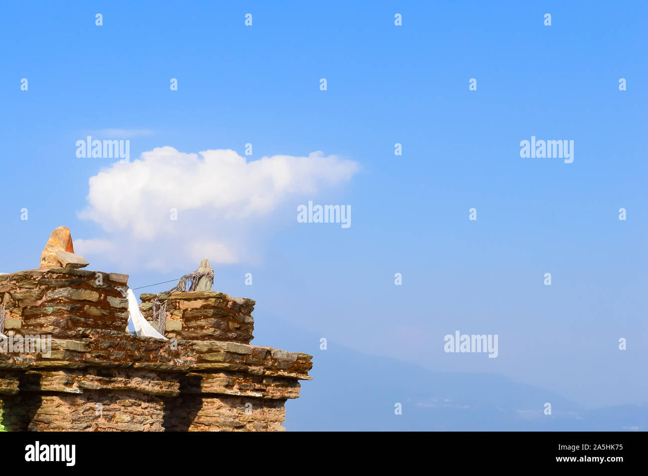 Vecchio rovinato pietra arenaria da parete in pietra sullo sfondo contro il cielo blu con lana di cotone nuvole e Monte Kangchendzonga gamma. Rovine Rabdentse, West Sikkim, in Foto Stock