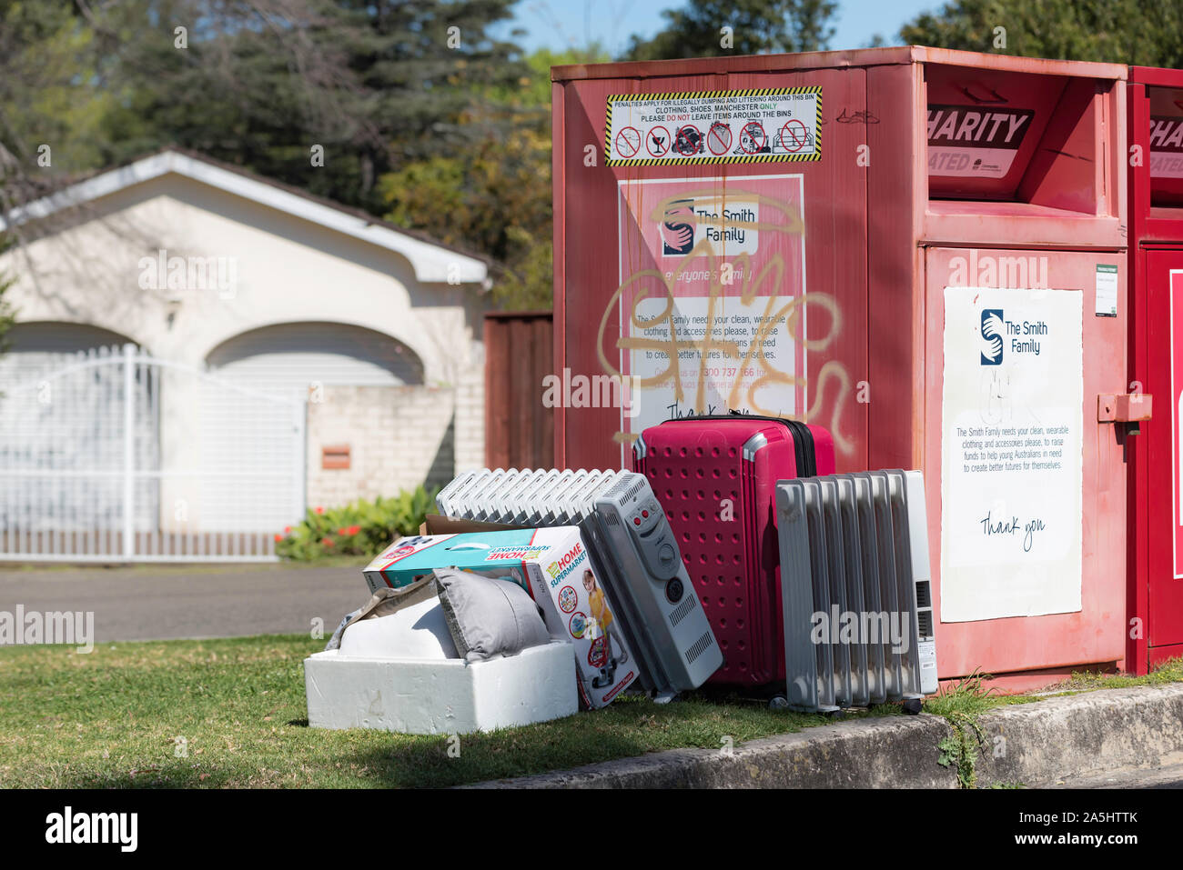Beni di consumo oggetto di dumping accanto a una carità bin in un sobborgo di Sydney. Le associazioni di beneficenza spendono milioni di dollari ogni anno lo smaltimento dei rifiuti oggetto di dumping Foto Stock