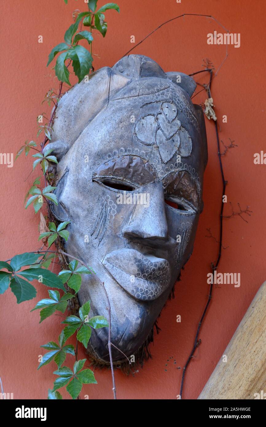 Tribale africano maschera cerimoniale su una parete arancione maschera dello Zambia Foto Stock