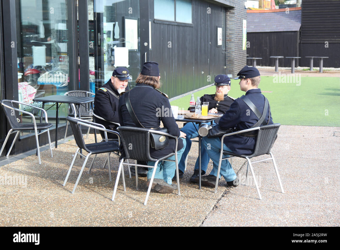 Un gruppo di Soskan rievocazione Unione soldati in uniforme di relax al di fuori di un cafe tra mostra, 2019 Foto Stock