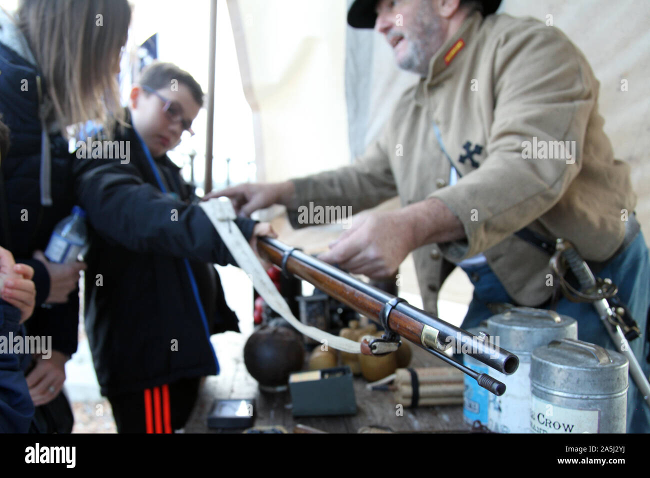 Un Soskan Guerra civile rievocazione soldato dell'Unione rappresenta un fucile utilizzato negli Stati Uniti conflitto a un volenteroso bambino turistica, 2019 Foto Stock