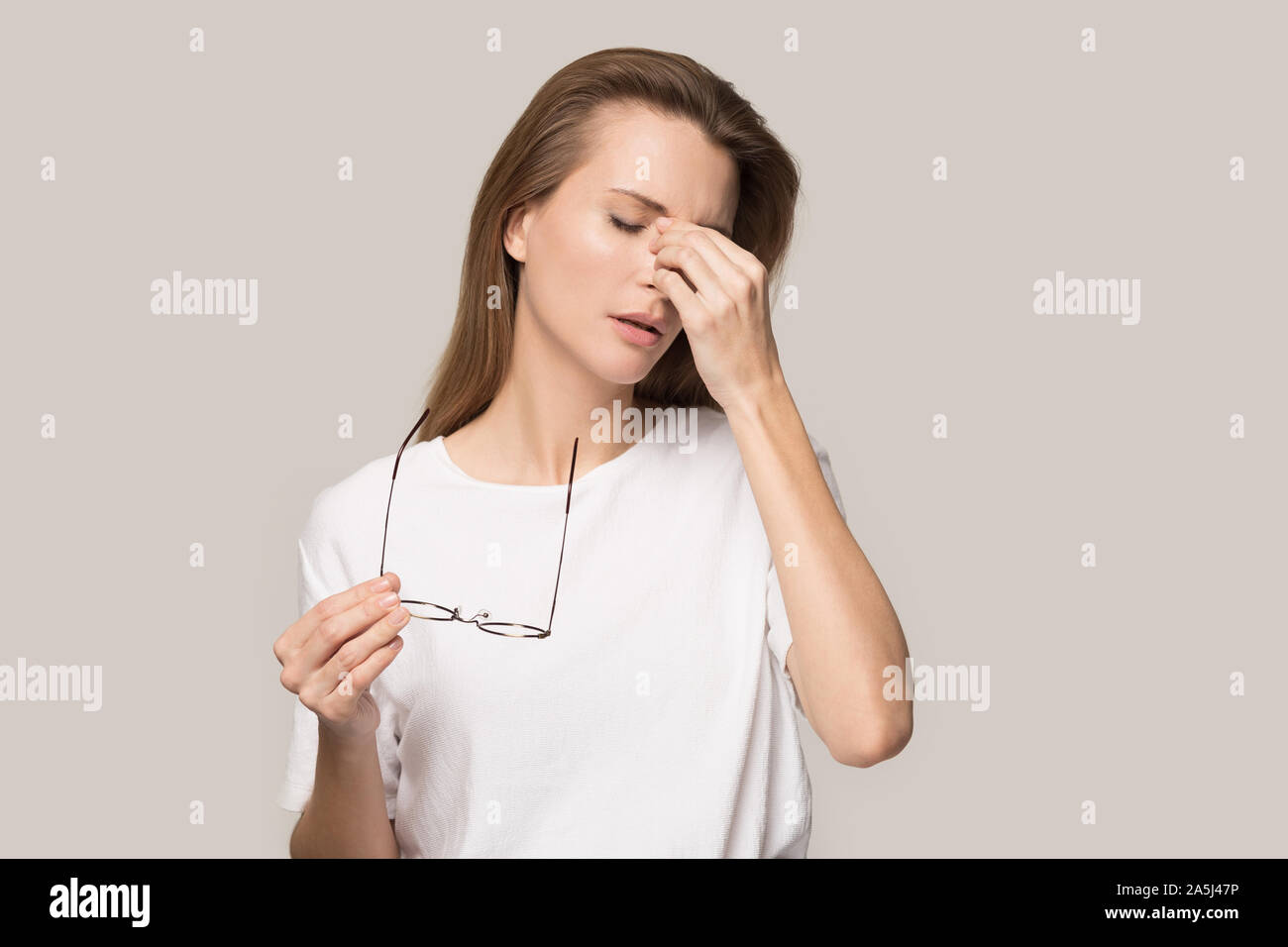 Stanco donna togliere i bicchieri soffrono di mal di testa Foto Stock