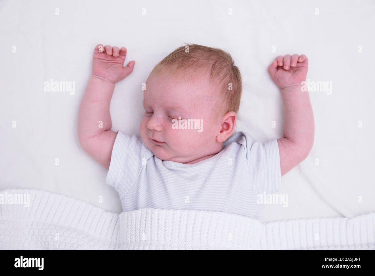 Un sonno giovane bambino con le loro braccia verso l'alto. Carino il bambino addormentato Foto Stock