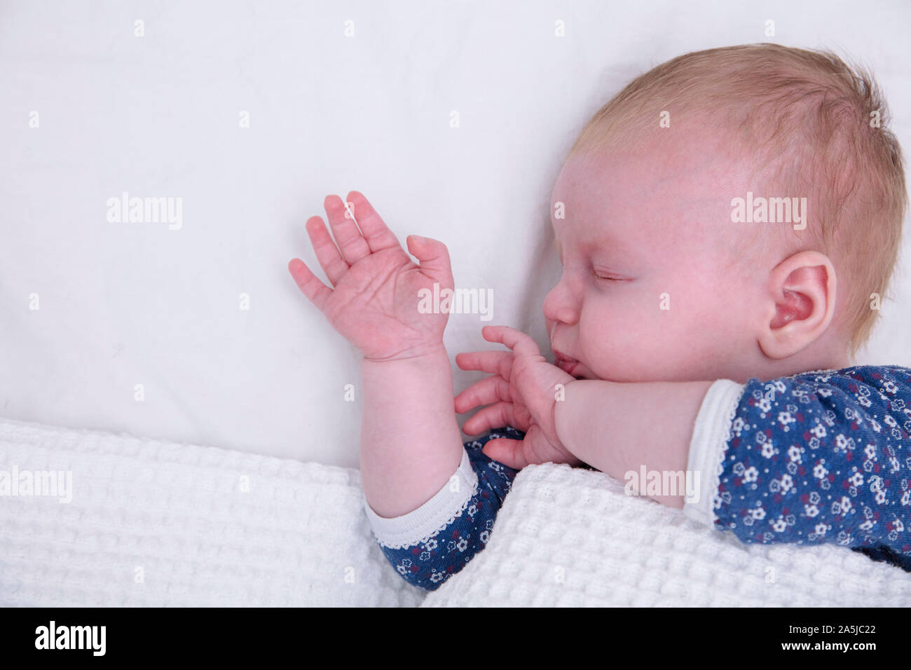 Un sonno giovane bambino con le loro braccia verso l'alto. Carino il bambino addormentato Foto Stock