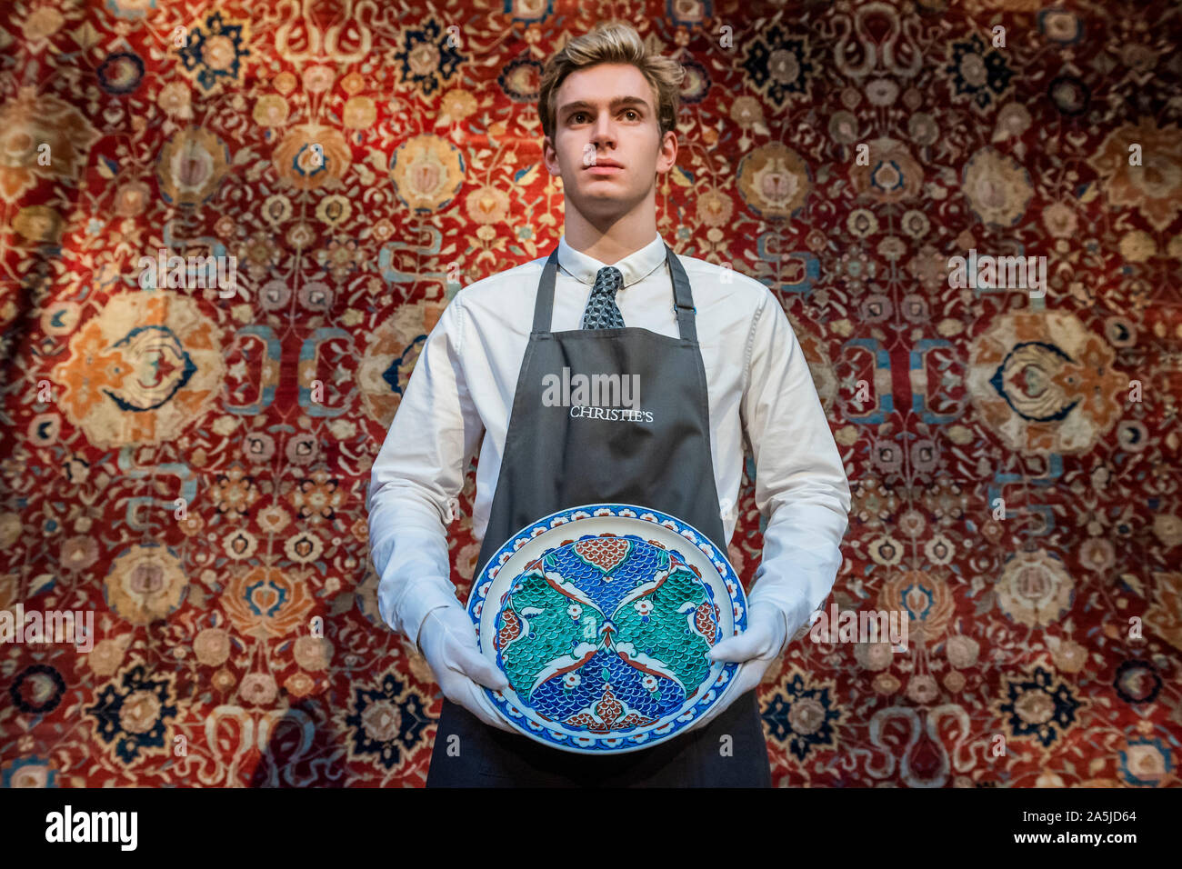 Westminster, Londra, Regno Unito. 21a Ott 2019. Un ceramiche di Iznik piatto, C1580, est £2-30,000, e uno degli enormi tappeti in arte islamica e mondi indiano vendita. Un'anteprima prima di Christie's Arte Islamica settimana sulle aste 23, 24 e 25 ottobre. Credito: Guy Bell/Alamy Live News Foto Stock