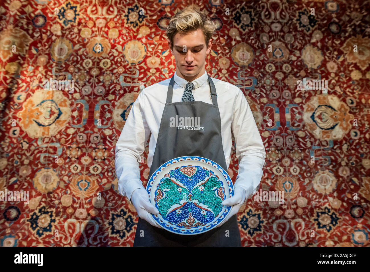 Westminster, Londra, Regno Unito. 21a Ott 2019. Un ceramiche di Iznik piatto, C1580, est £2-30,000, e uno degli enormi tappeti in arte islamica e mondi indiano vendita. Un'anteprima prima di Christie's Arte Islamica settimana sulle aste 23, 24 e 25 ottobre. Credito: Guy Bell/Alamy Live News Foto Stock