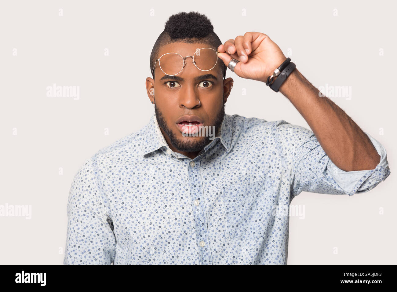 Scioccato biracial uomo guardare fotocamera sorpreso da news Foto Stock