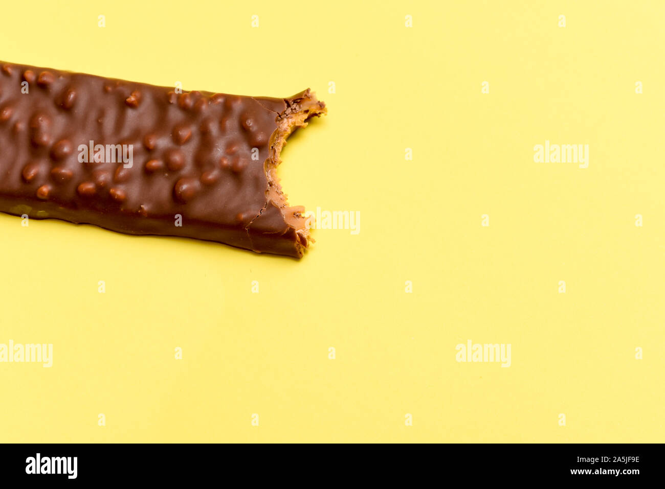 Gustosa barretta al cioccolato con un morso preso isolato ad alto contenuto calorico snack alimentare Foto Stock