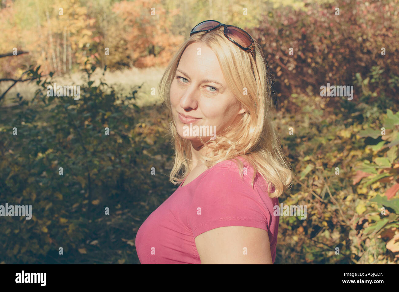 Ritratto di una donna matura con lunghi capelli biondi in autunno foresta colorata Foto Stock