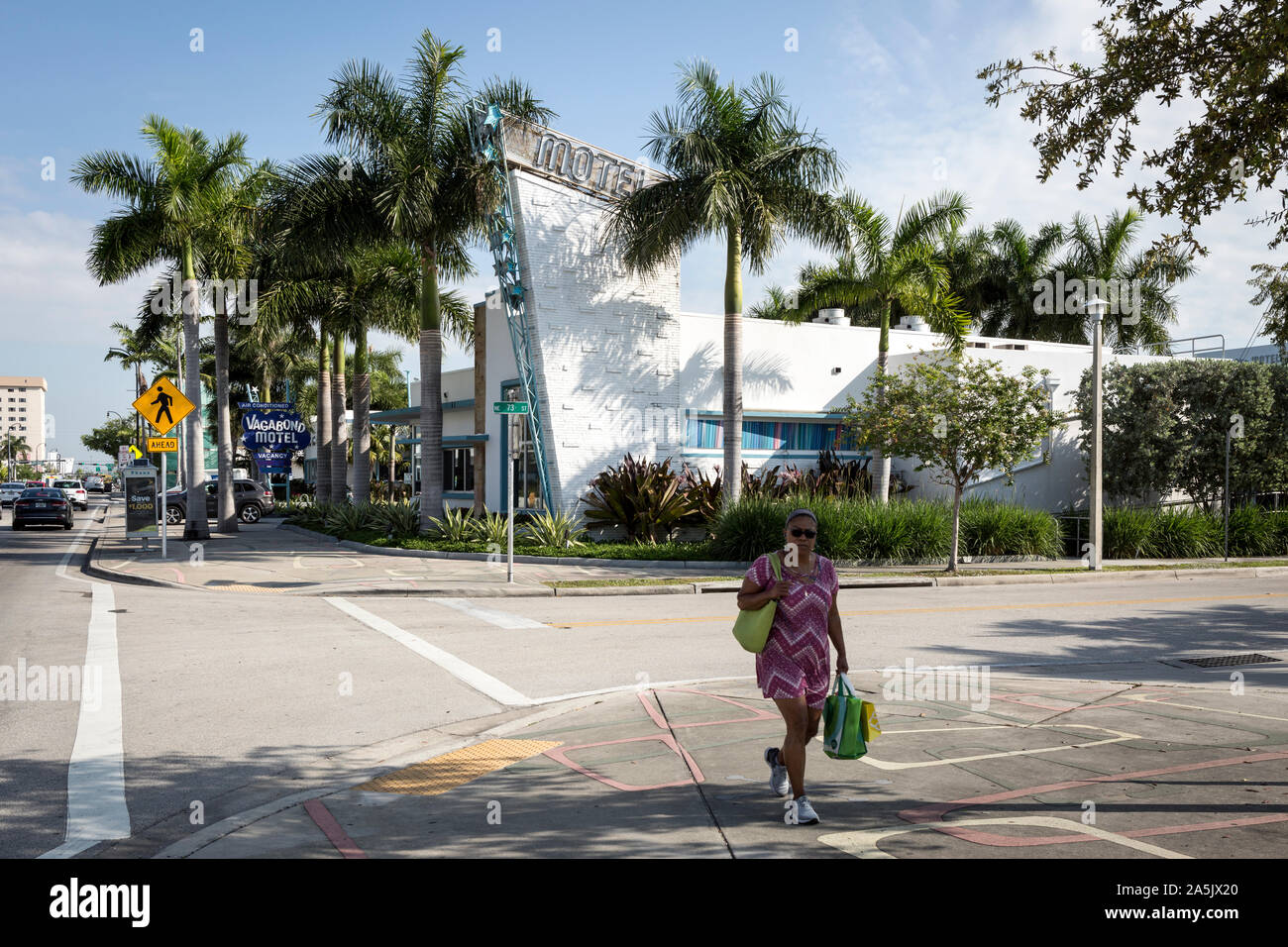 Una donna attraversa la strada di fronte al rinnovato metà secolo moderno Vagabond Motel sulla Biscayne Boulevard in Miami, Flordia, STATI UNITI D'AMERICA Foto Stock