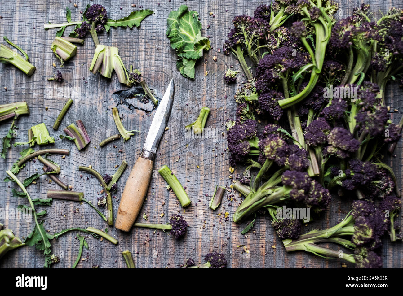 Angolo alto close up viola broccoletti e Coltelli con manico in legno. Foto Stock