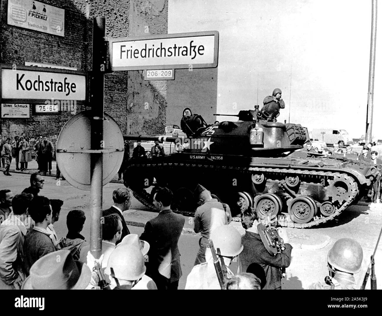 Agosto 1961 - STATI UNITI Il serbatoio e i fucilieri Guardia di Friedrichstrasse attraversamento della città divisa di settore come confine ovest i berlinesi guardano su Foto Stock