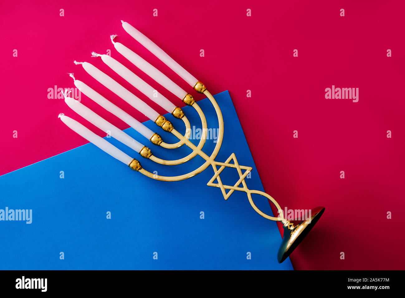 Jewish Hanukkah menorah in rosa e sfondo blu Foto Stock